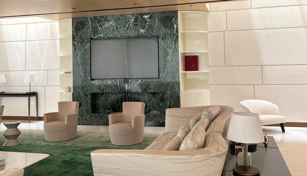Residential lounge with green marble feature wall and cream sofas